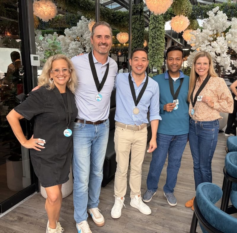 Ben Hoffman posing with four participants wearing medals at a cityHUNT scavenger hunt event